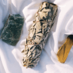 Rough crystal, white sage bundle and palo santo stick.